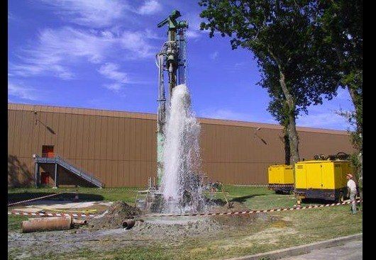 Forage d'eau en fonctionnement, jet d'eau jaillissant